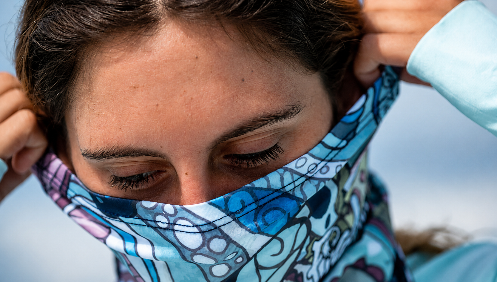 Person wearing a colorful patterned headscarf with a blurred background
