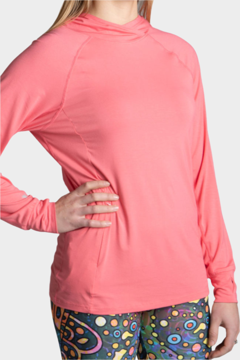 A person wearing a pink Stonefly Sunshirt with a hood, long sleeves, and a side gear pocket.