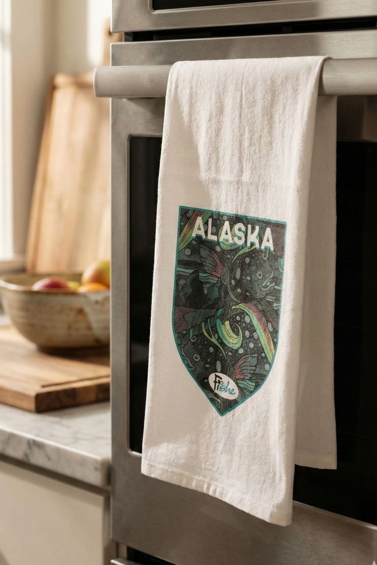 Kitchen towel with Alaska design hanging on a stove handle