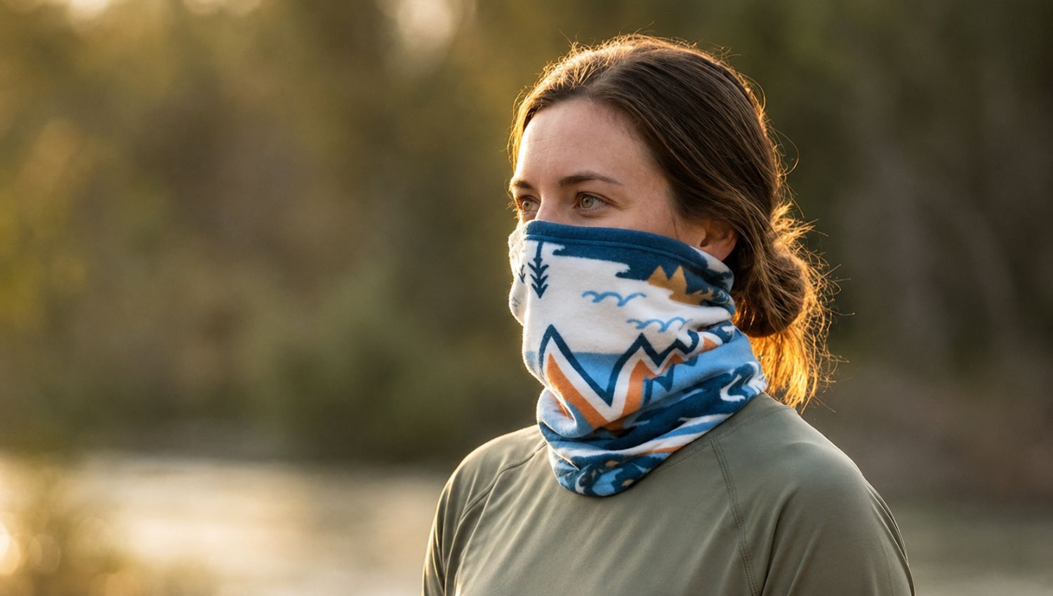 Person wearing a patterned face covering outdoors with a blurred natural background