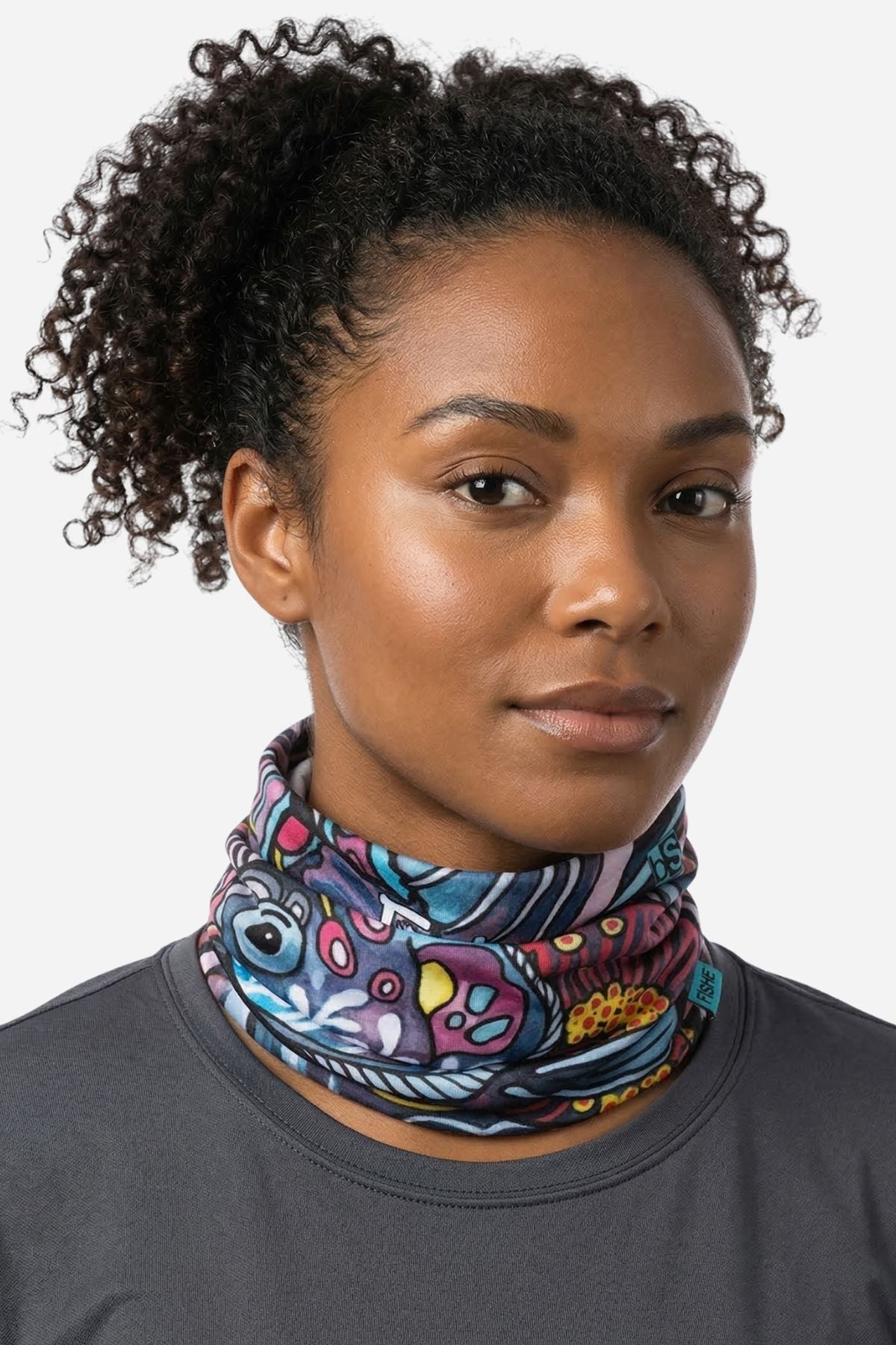 Woman wearing a colorful patterned neck gaiter against a white background