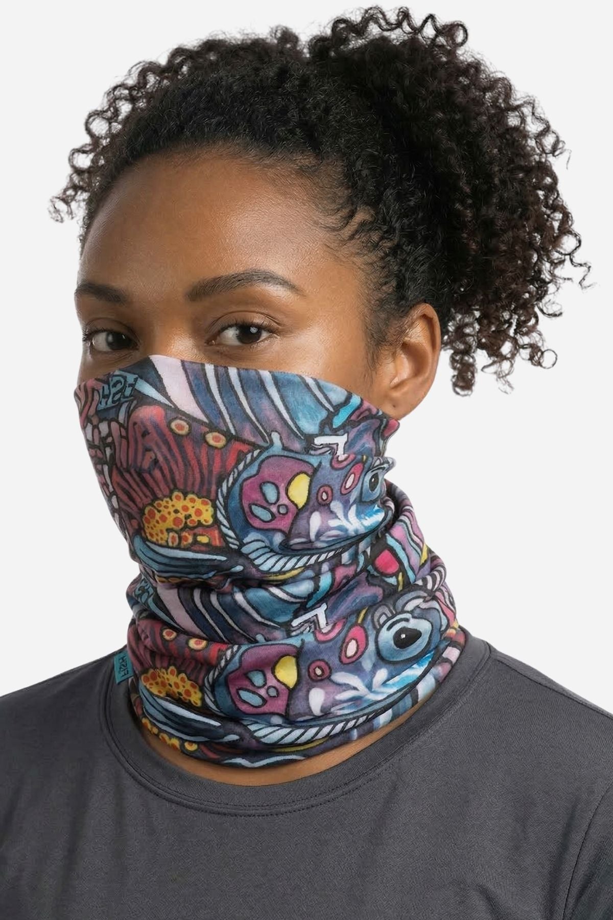 Person wearing a colorful patterned face mask on a plain background