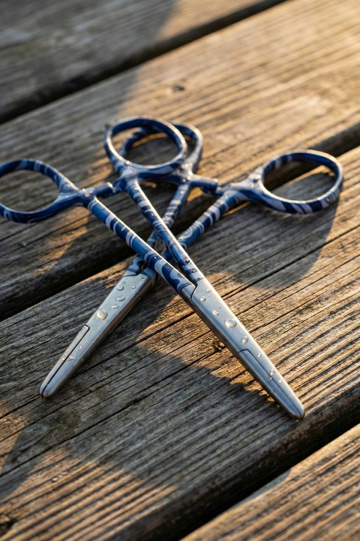 Pair of scissors with blue handles on a wooden surface