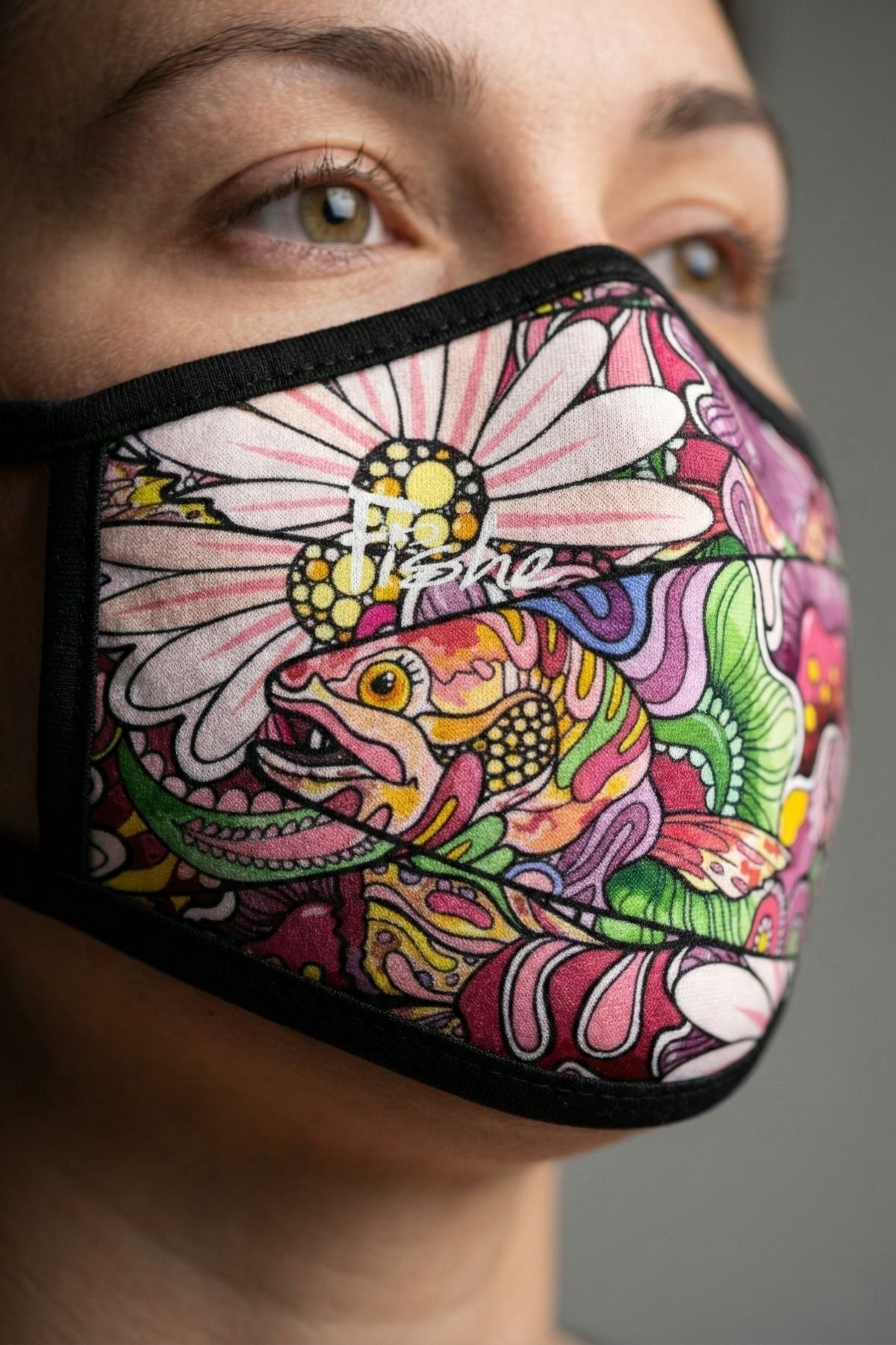 Colorful face mask with floral and fish design worn by a person