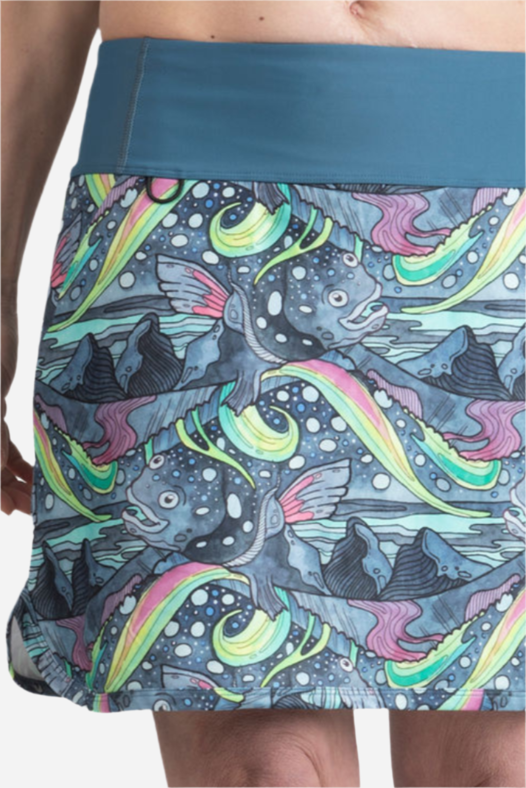 Colorful fish-patterned skirt worn by a person on a white background