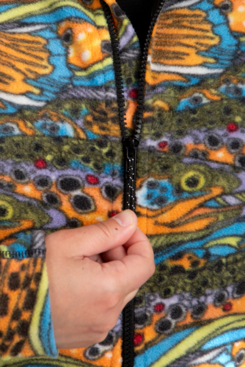 Colorful jacket with fish pattern held by a hand