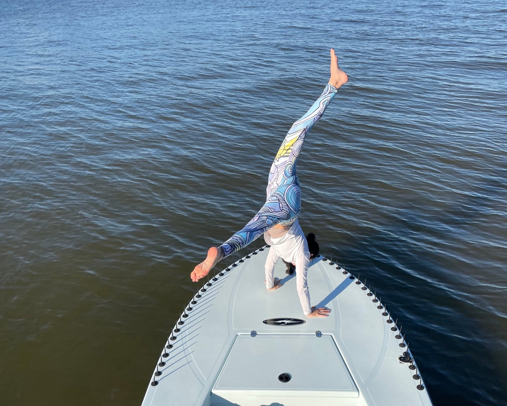 Emily Mauri doing a handstand on a fishing boat in Fishe leggings