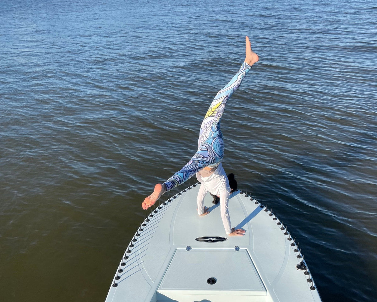 Emily Mauri doing a handstand on a fishing boat in Fishe leggings