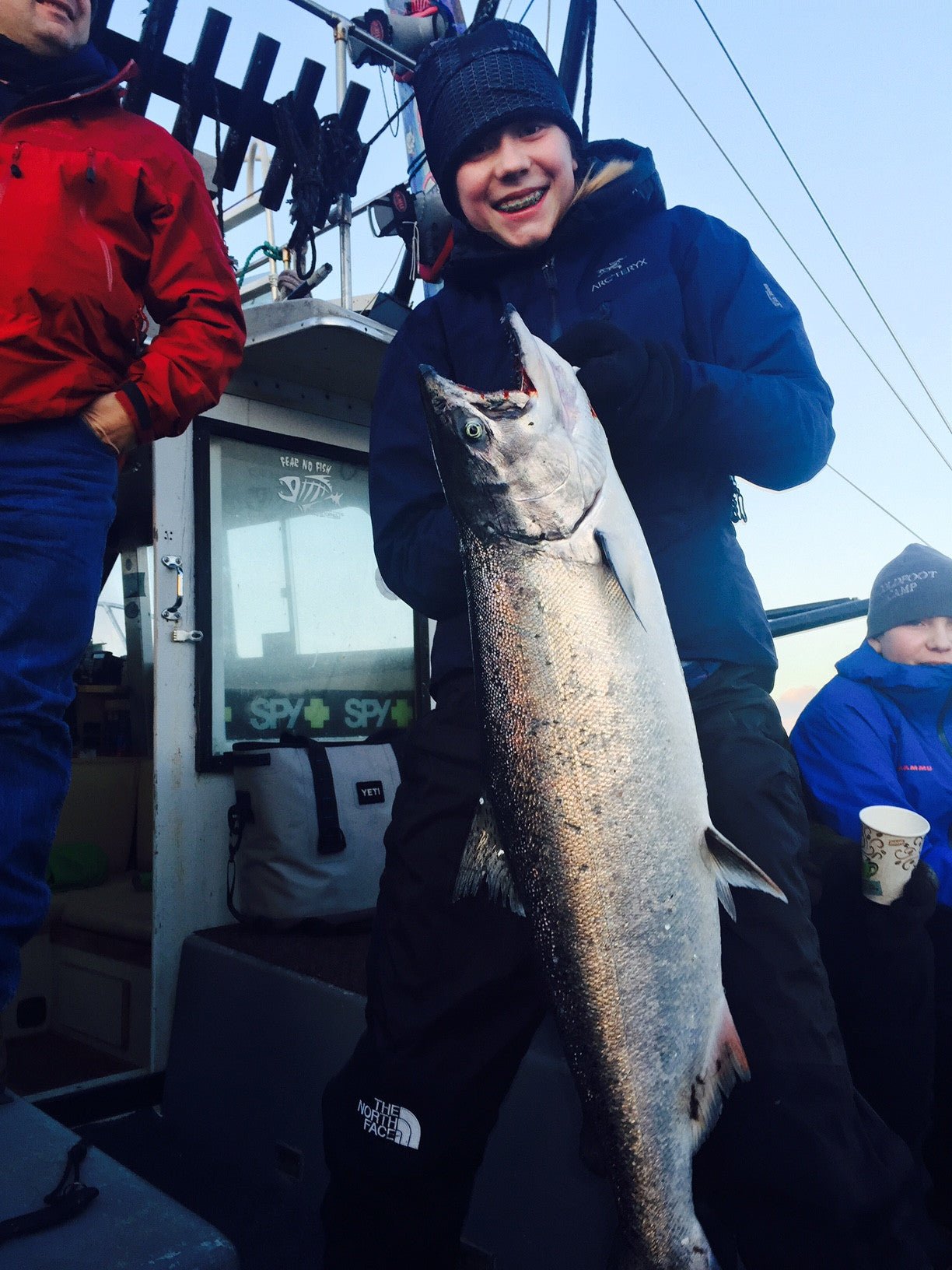 Young angler holding a winter king salmon, representing fishing’s next generation