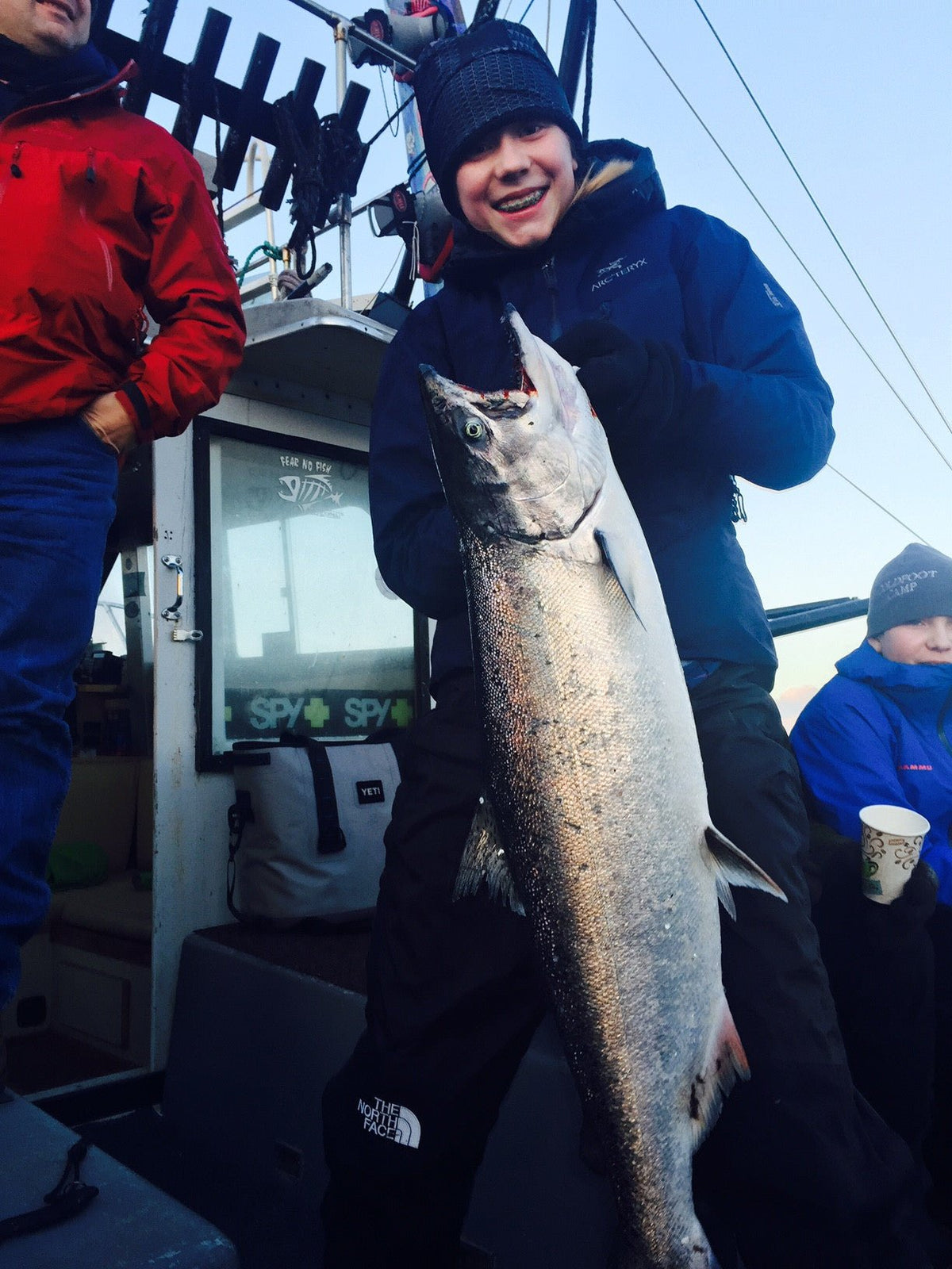 Young angler holding a winter king salmon, representing fishing’s next generation