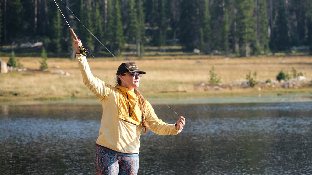 A Fishe angler fly casting beside a mountain lake
