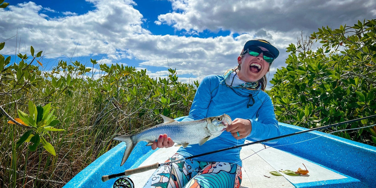 Ryan Scavo celebrating a baby tarpon catch during a fishing adventure