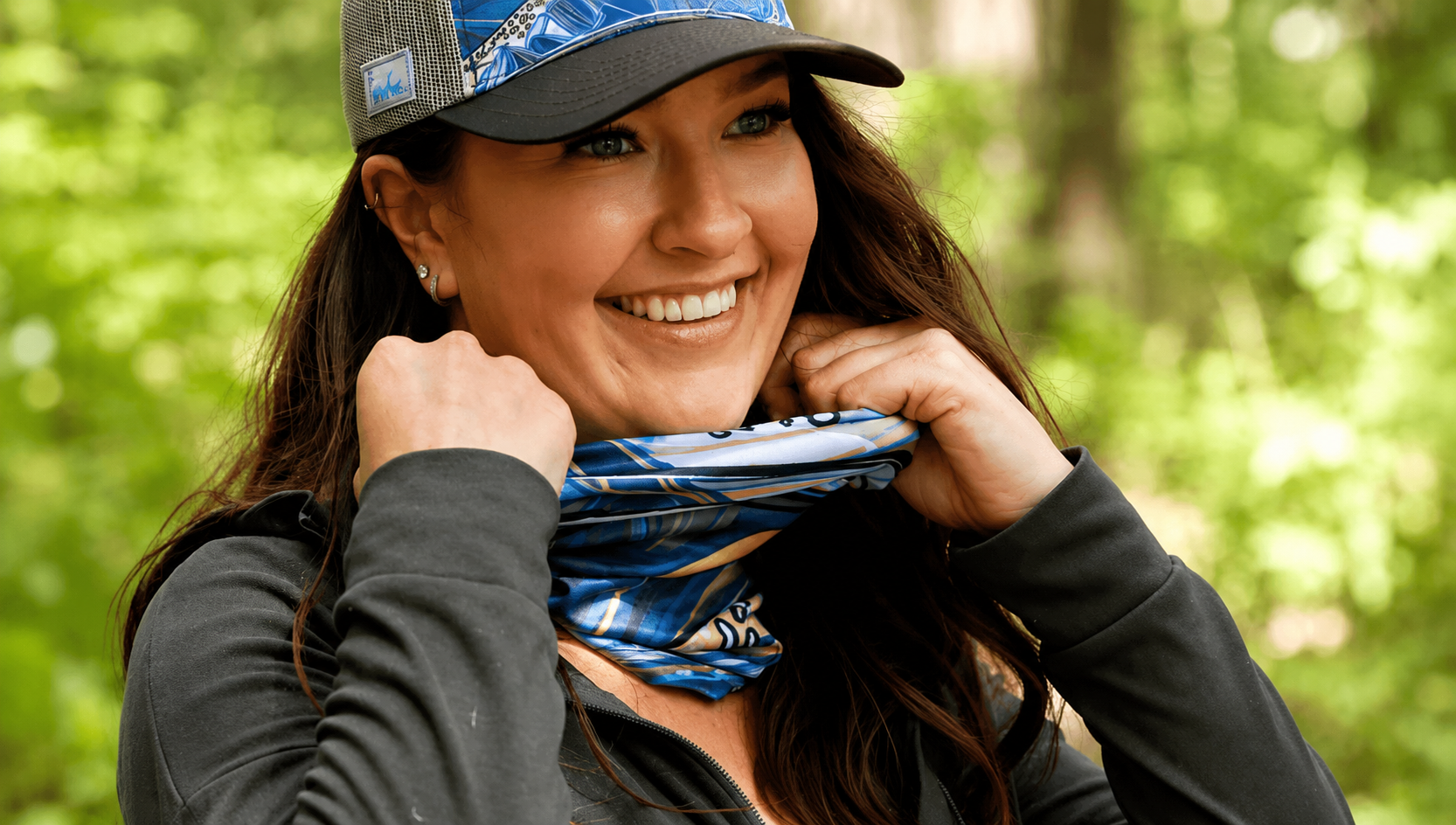 Woman wearing a blue cap and matching bandana in a forest setting
