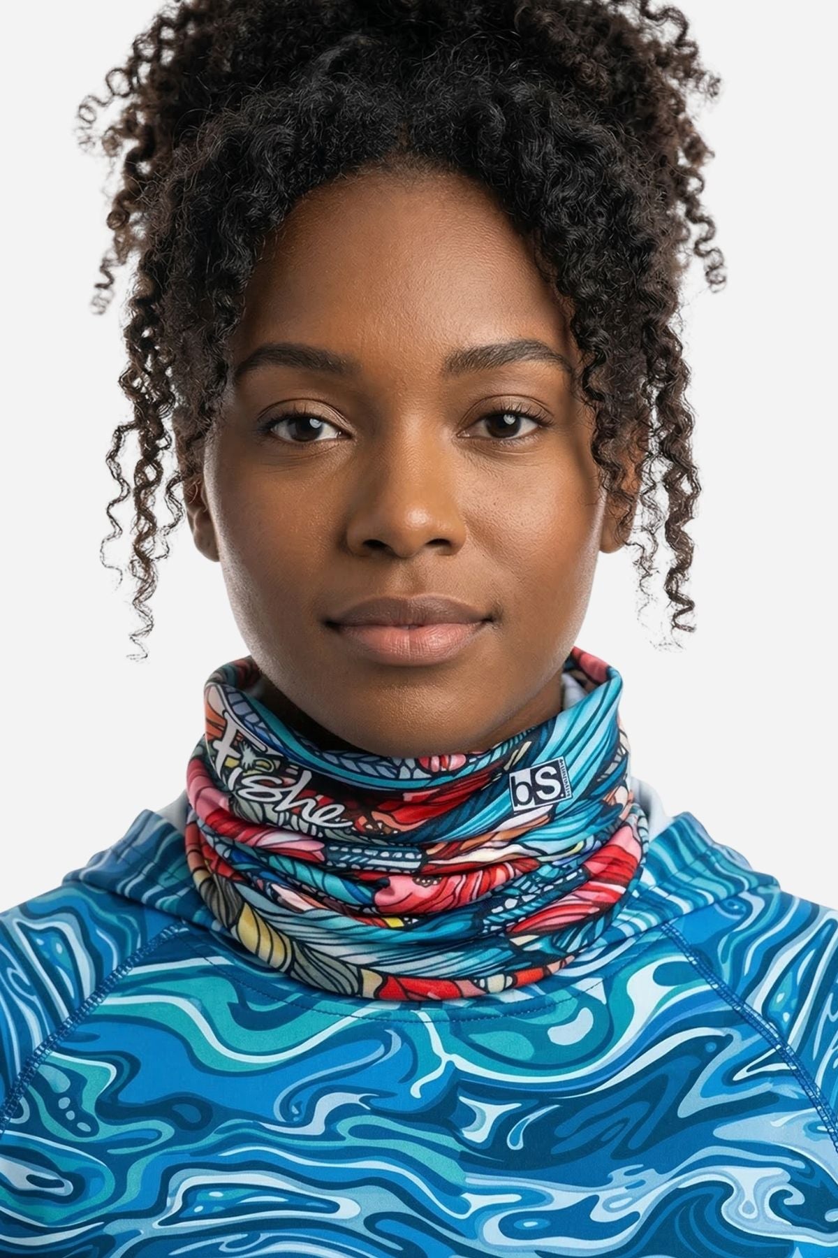 Person wearing a colorful patterned neck gaiter over a blue and white patterned shirt.