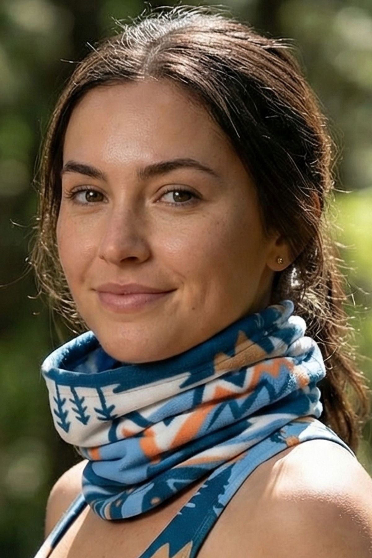 Woman wearing a patterned blue scarf with a blurred natural background