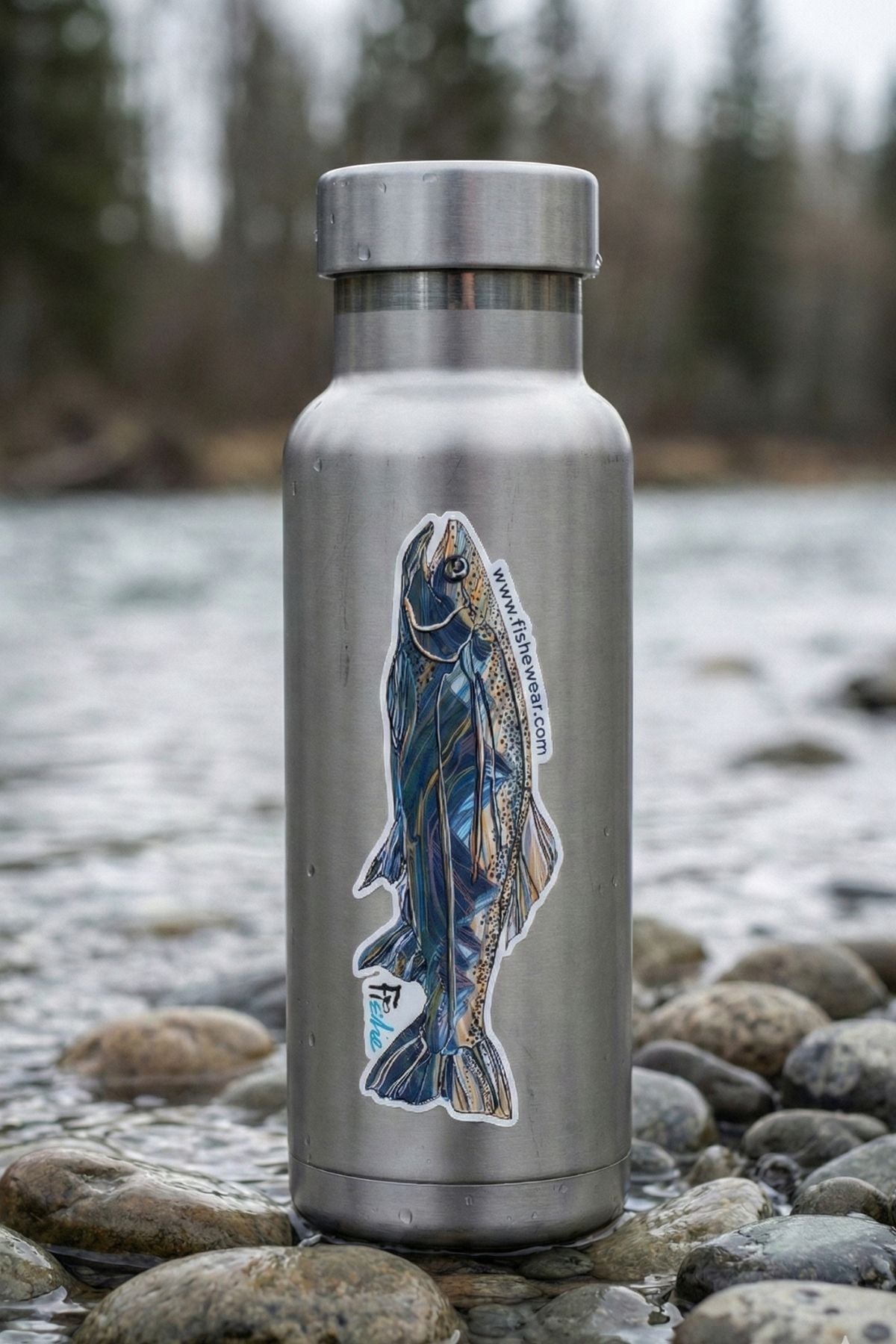 Stainless steel water bottle with a fish design on a rocky surface