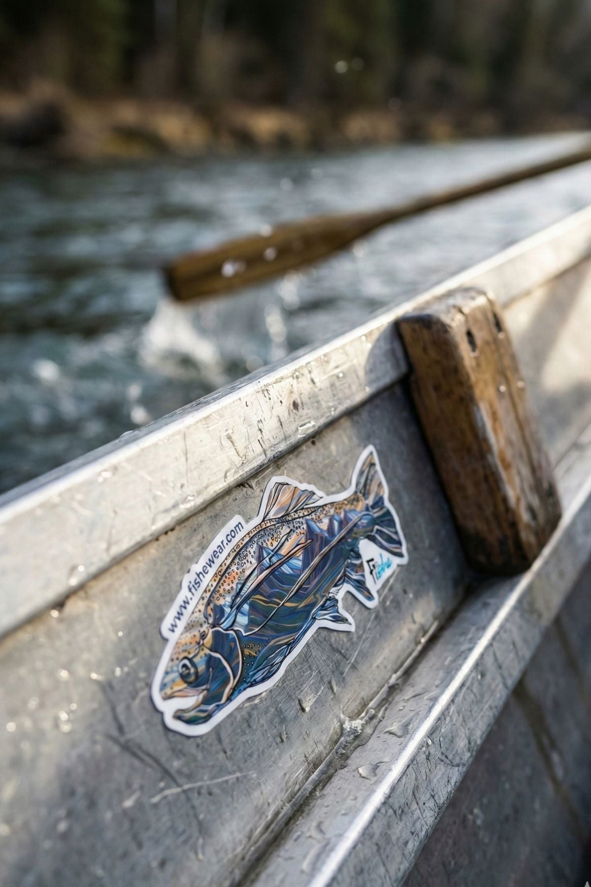 Sticker of a fish on the side of a metal boat on a river