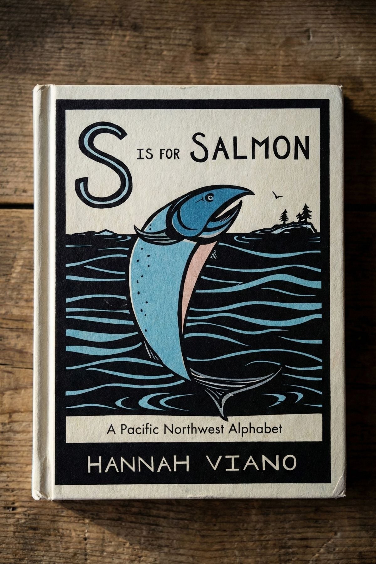 Book cover of 'S is for Salmon' by Hannah Viano on a wooden surface