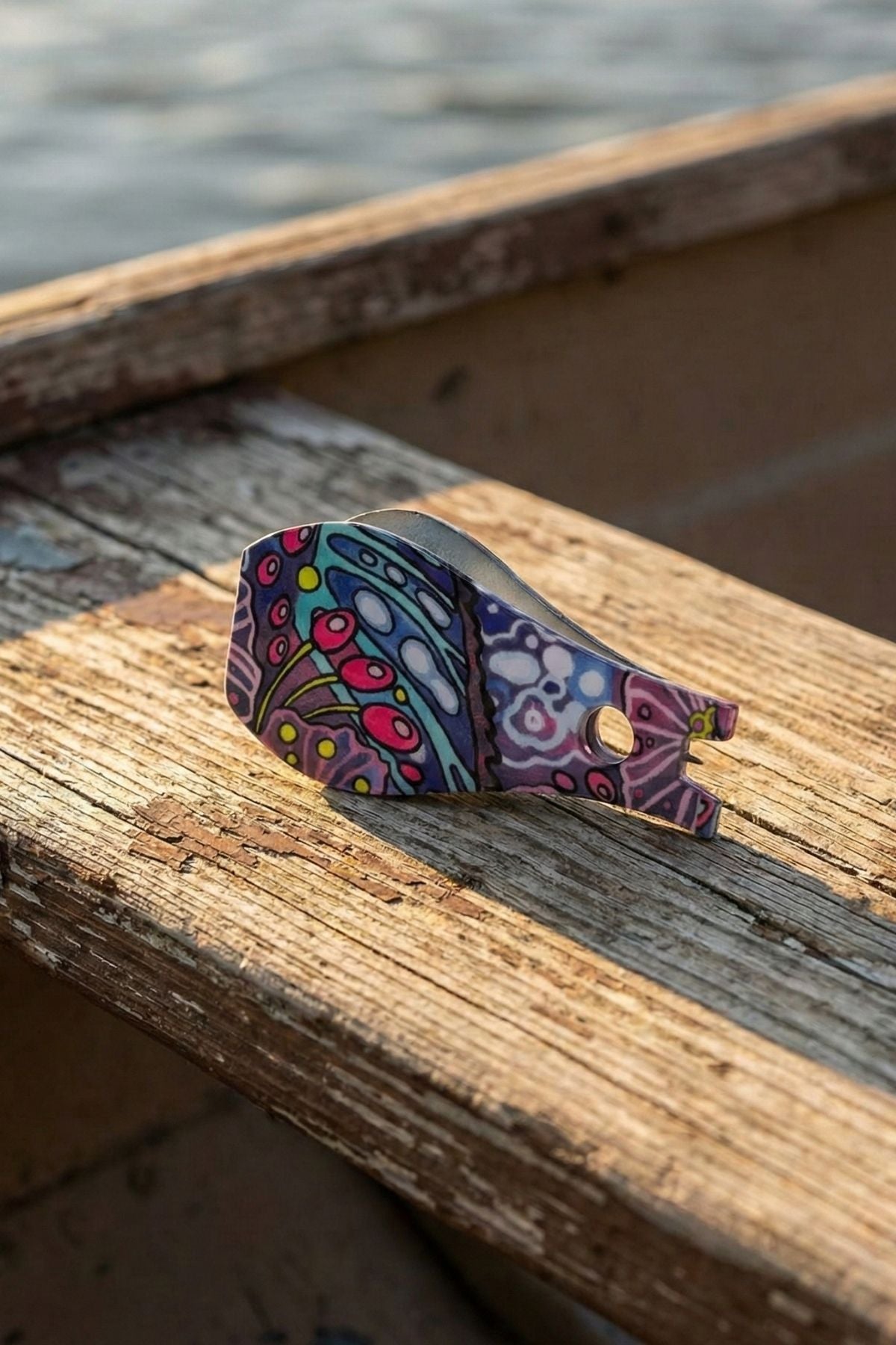 Colorful wooden ring with intricate patterns on a wooden surface