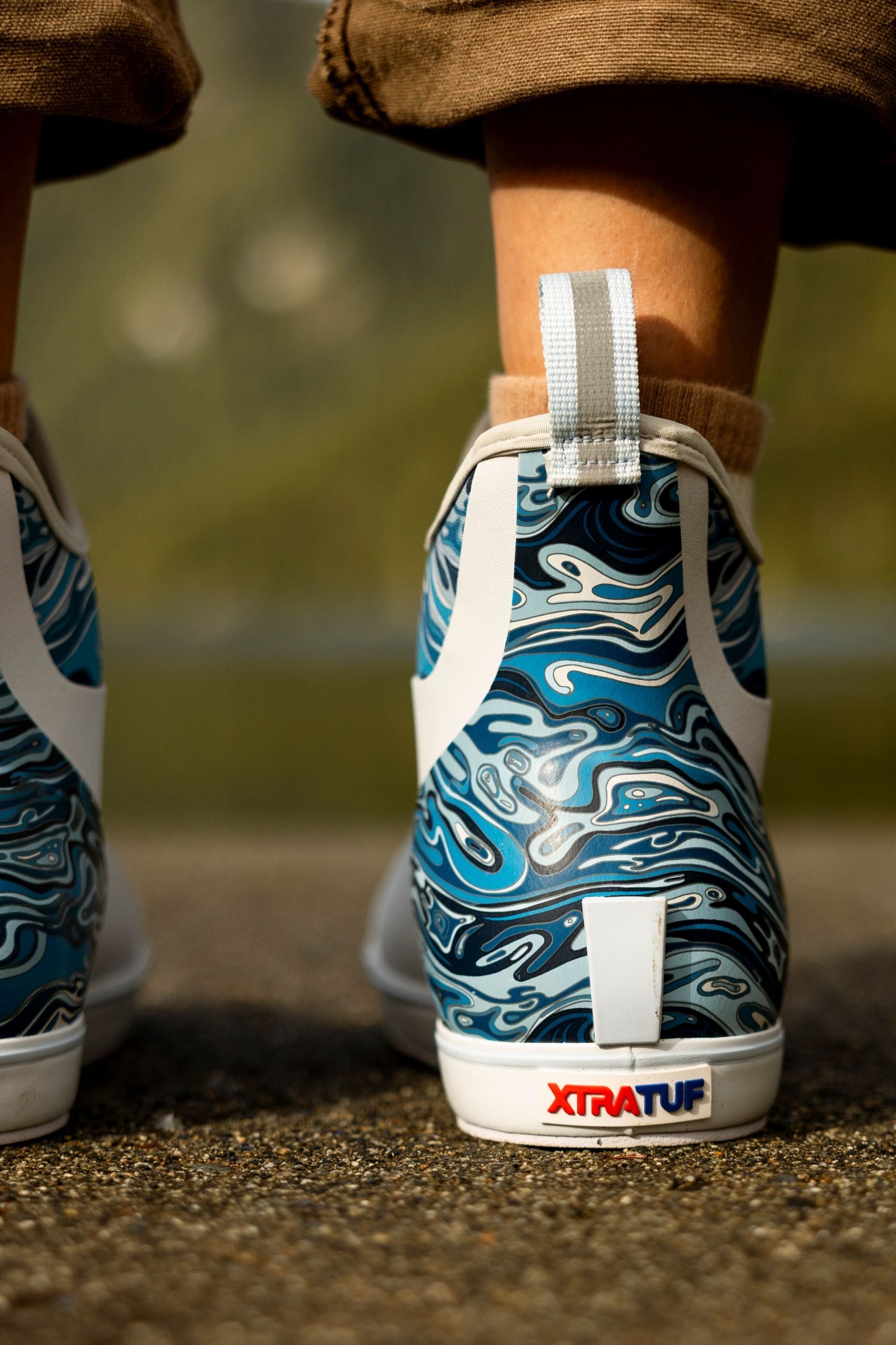 Blue and white patterned sneakers with 'XTRATUF' branding on a blurred background