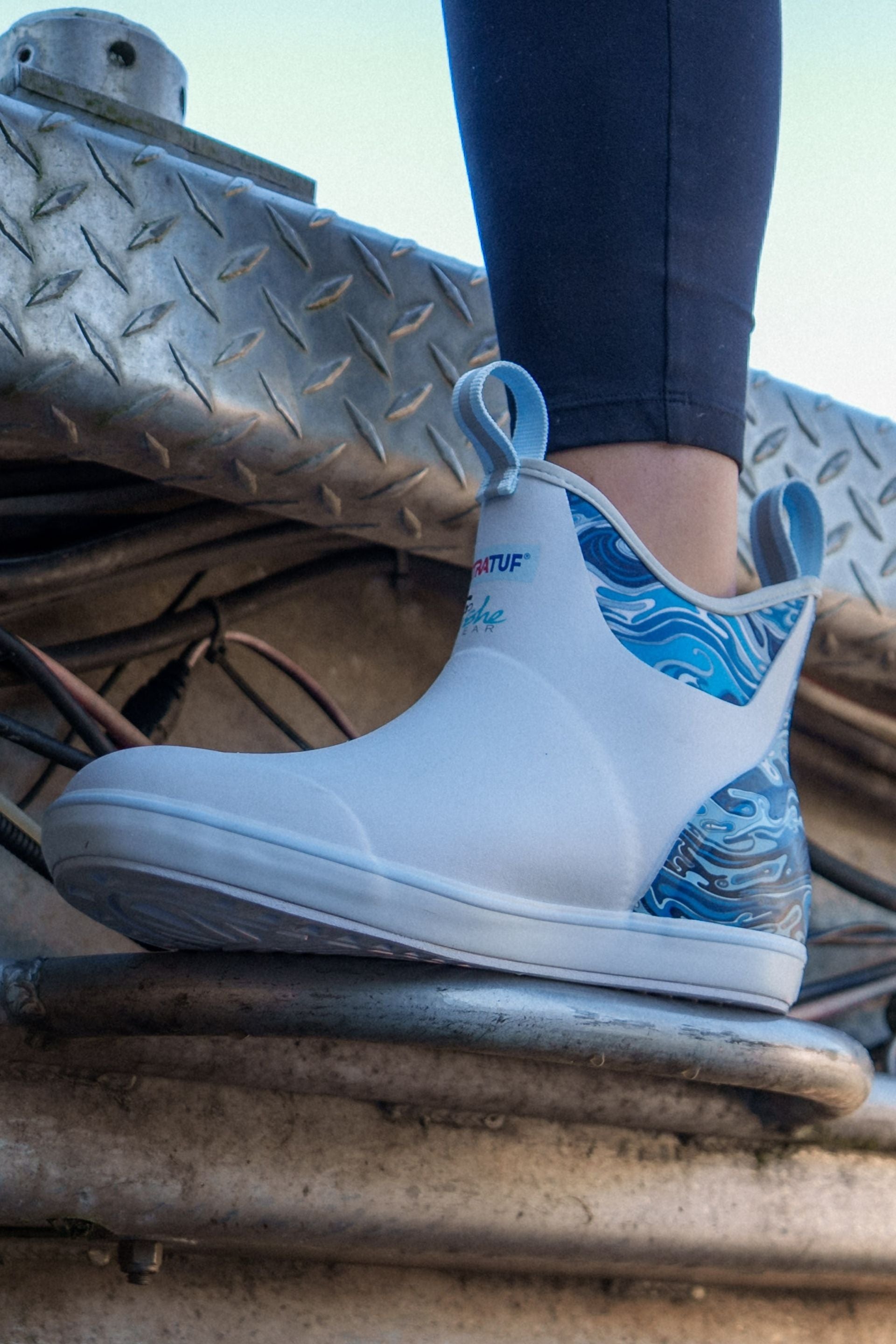 Blue and white shoe with wave design on a metal surface