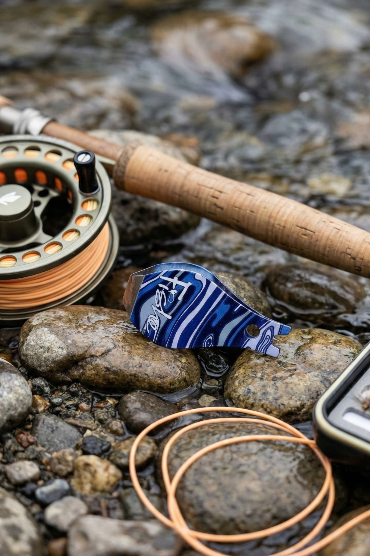 Fishing rod and reel on rocks near a stream
