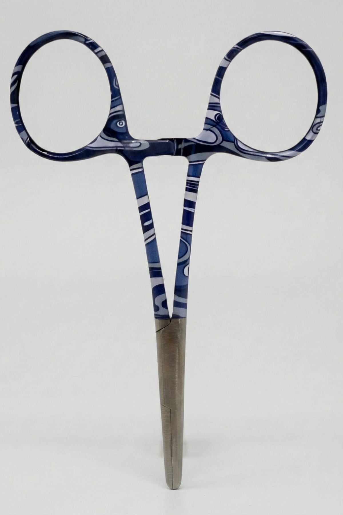 Pair of scissors with blue and white patterned handles on a light gray background