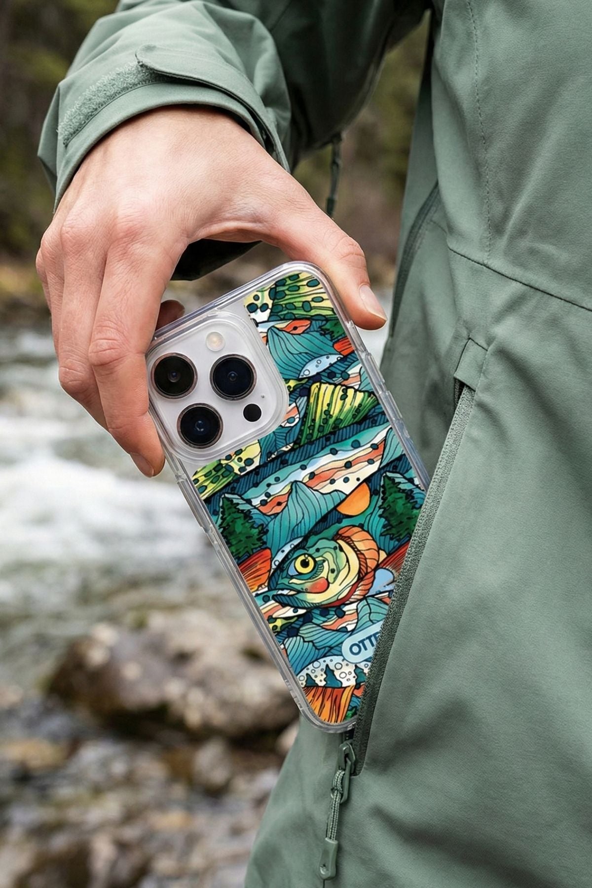 Person holding a phone with a colorful case near a natural setting