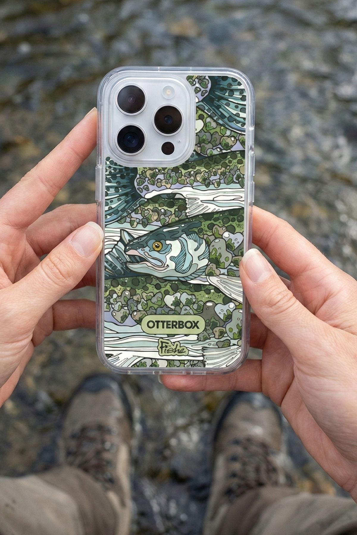 Phone case with fish design held by hands, brand 'OtterBox' visible