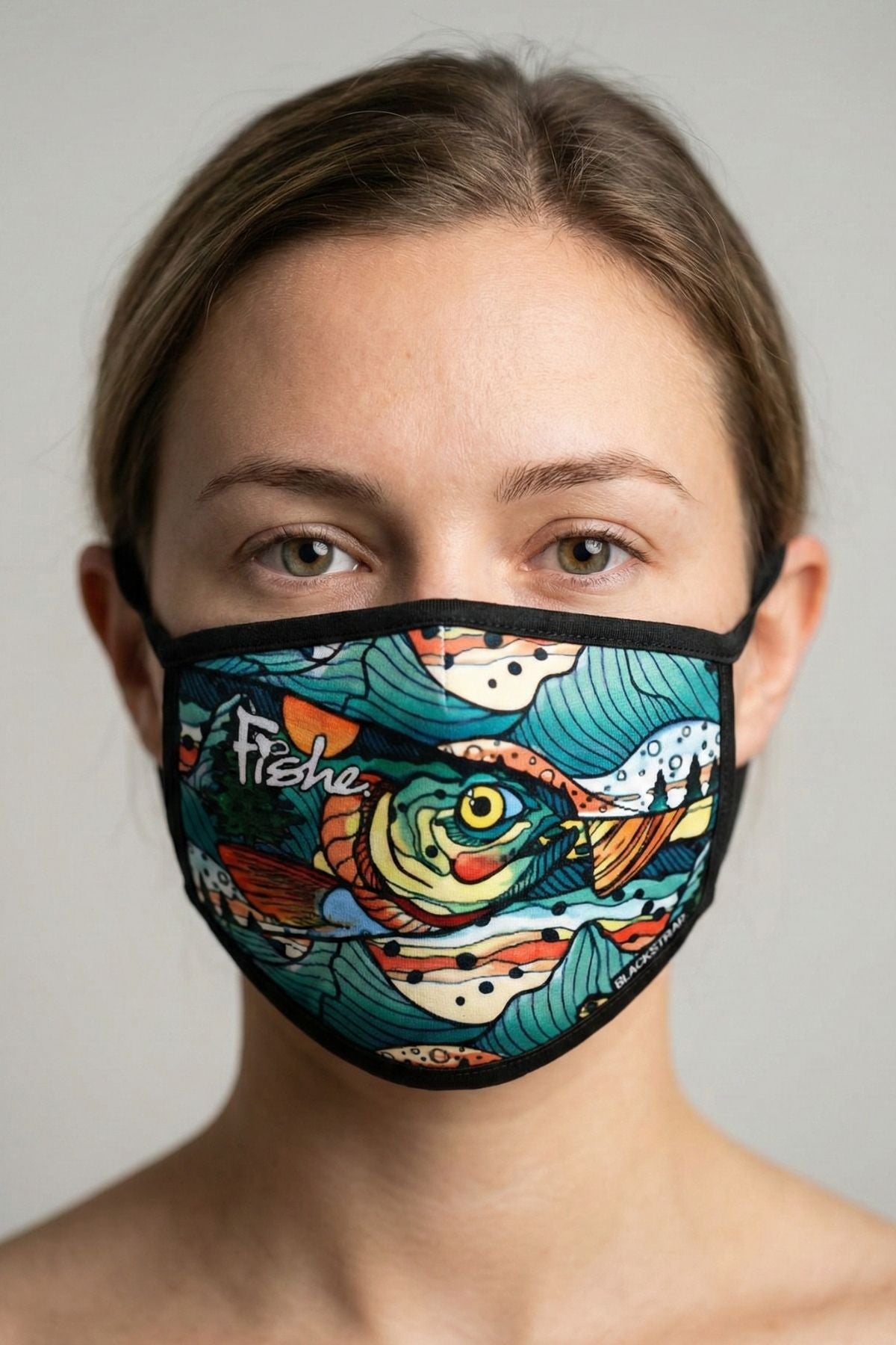Person wearing a colorful face mask with fish design on a plain background
