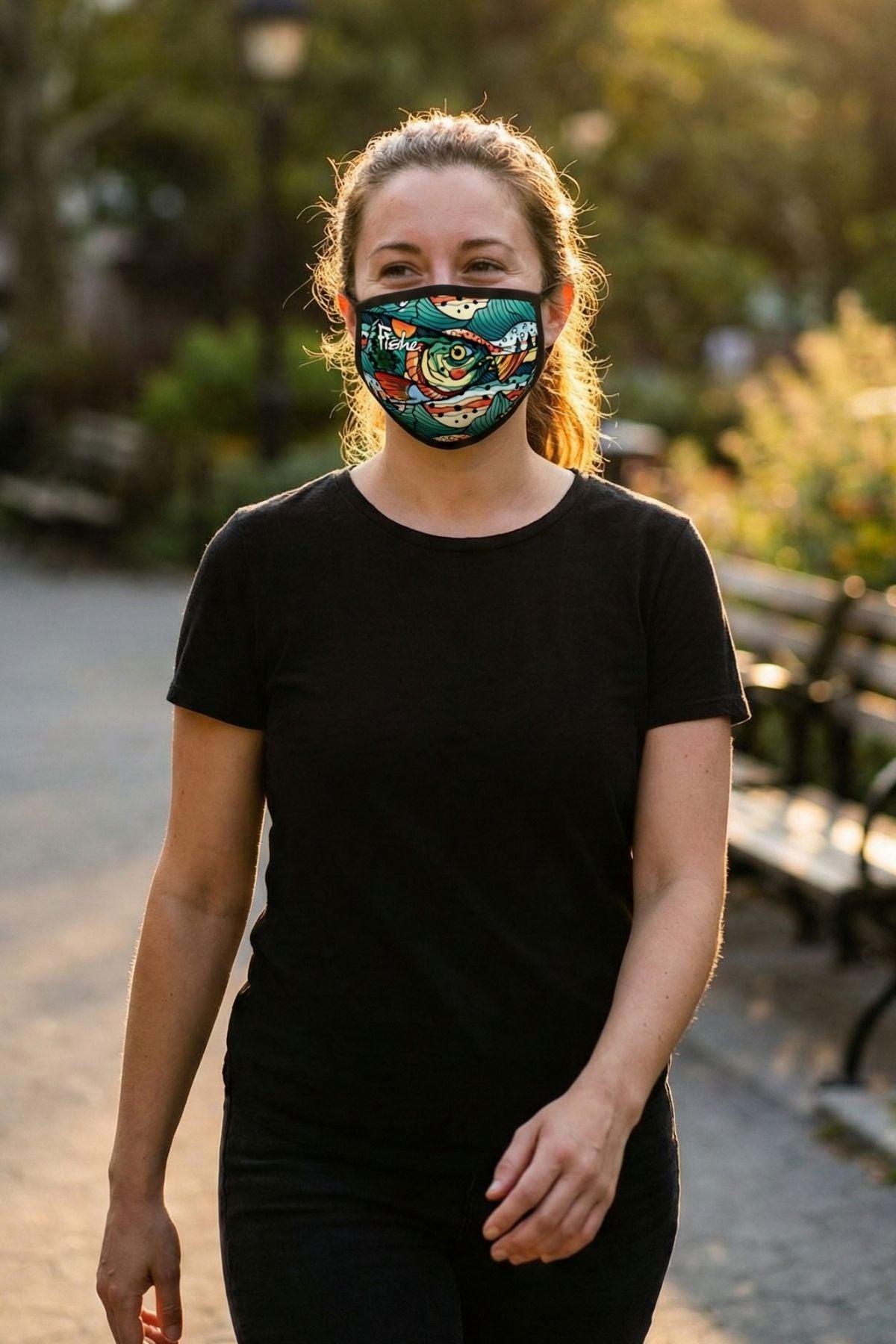 Person wearing a black t-shirt and colorful face mask in an outdoor setting