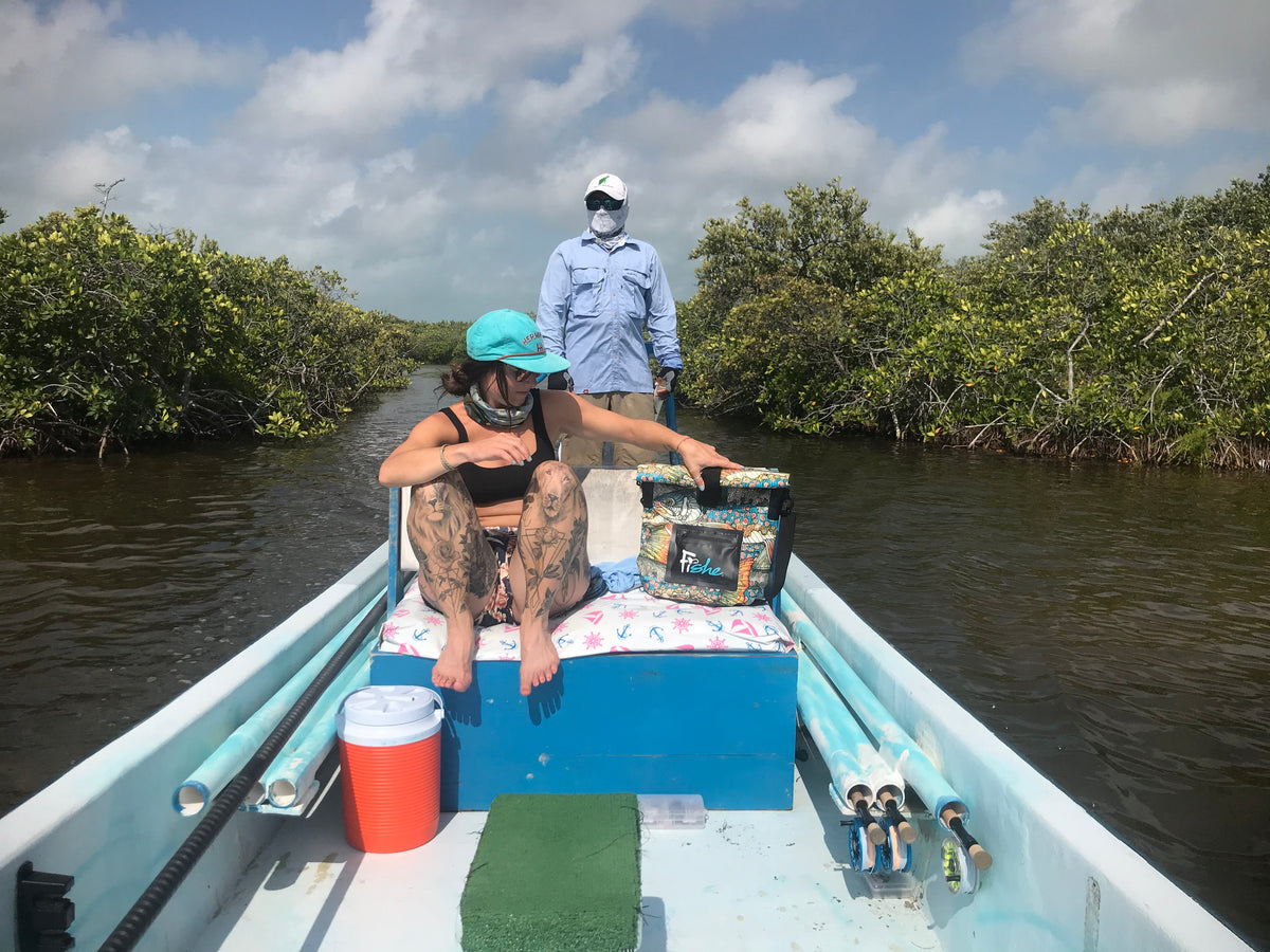 Angler on a flats skiff with a guide poling behind her