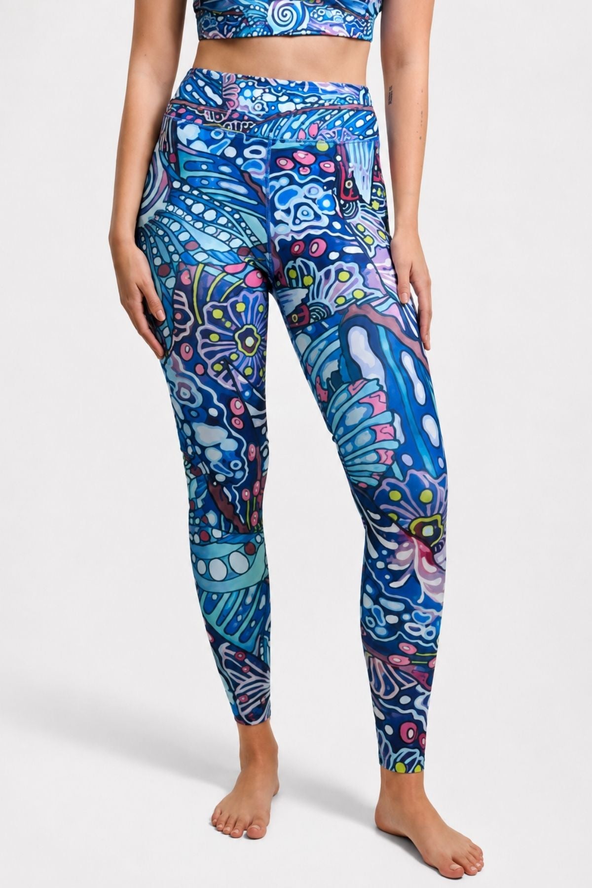 Person wearing colorful patterned leggings on a white background