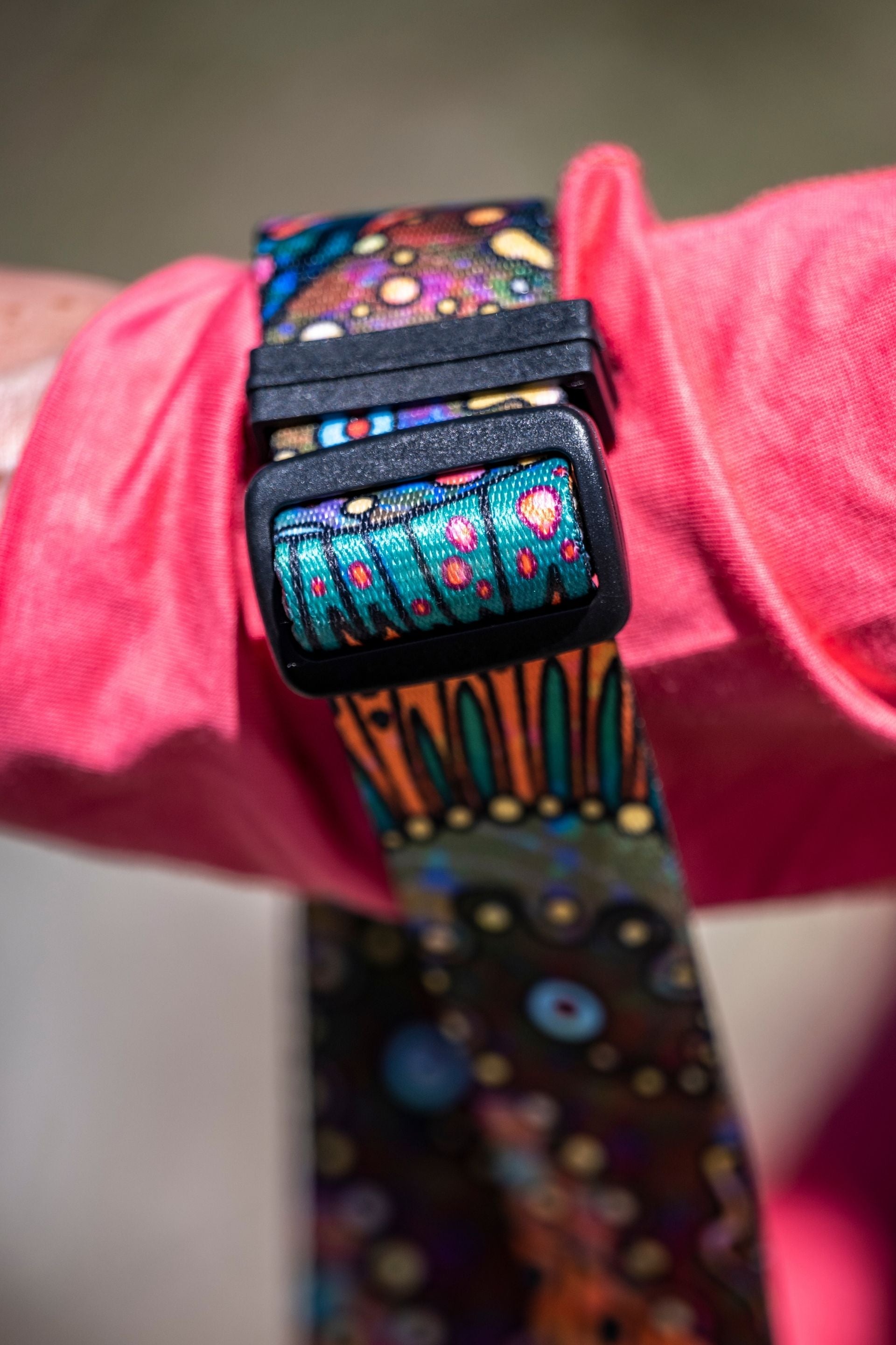 Colorful patterned belt with a pink fabric background