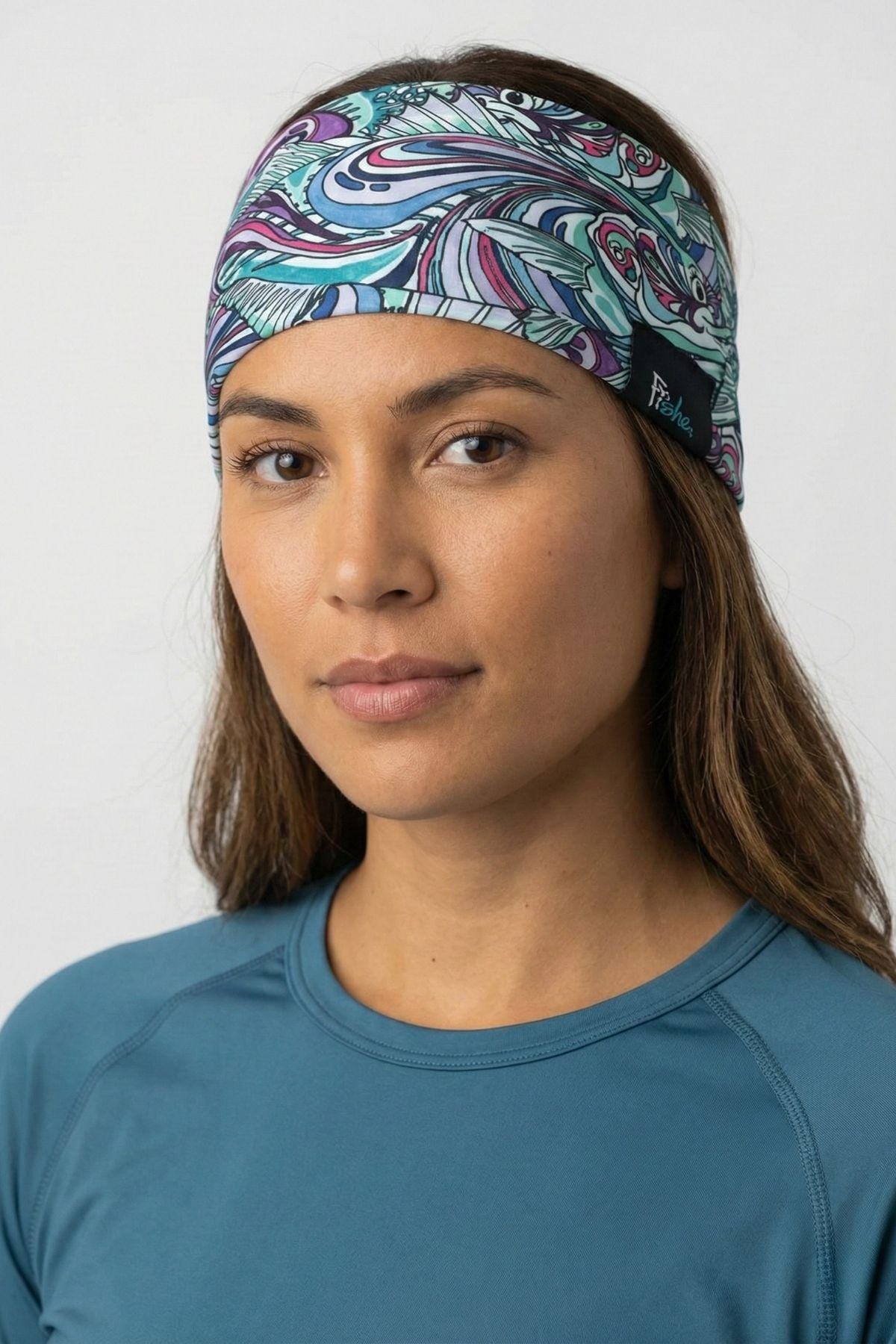 Woman wearing a colorful patterned headband against a white background